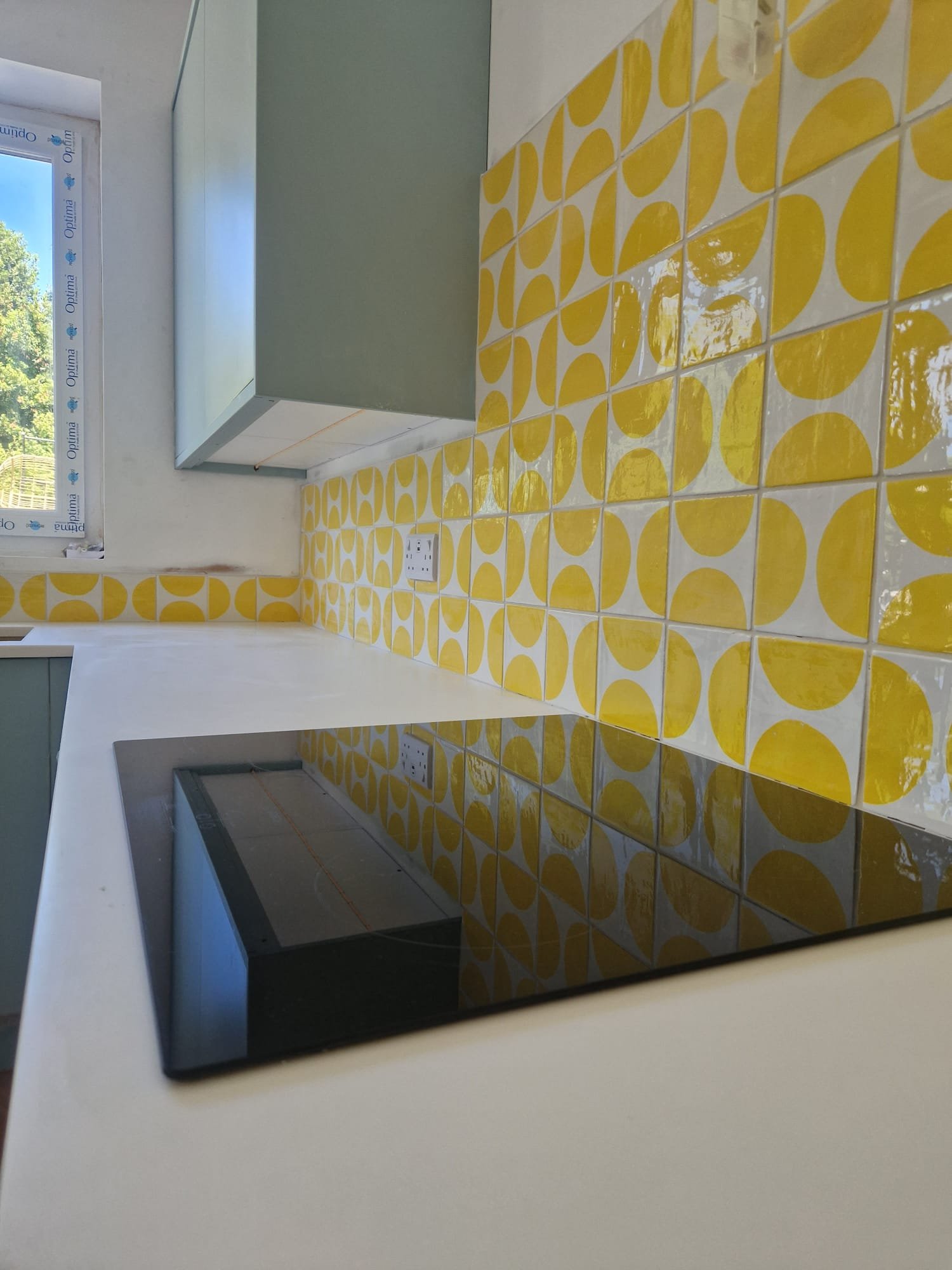 Yellow geometric tiled kitchen splashback