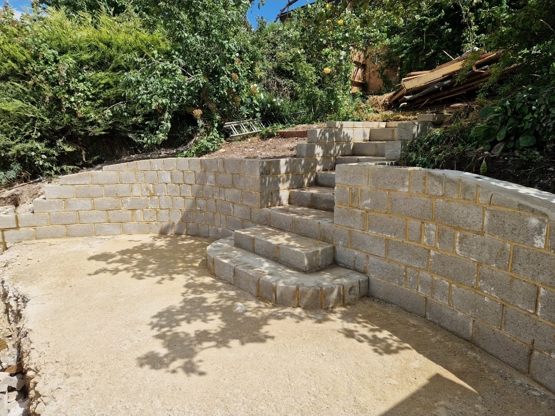 Curved block retaining wall with steps