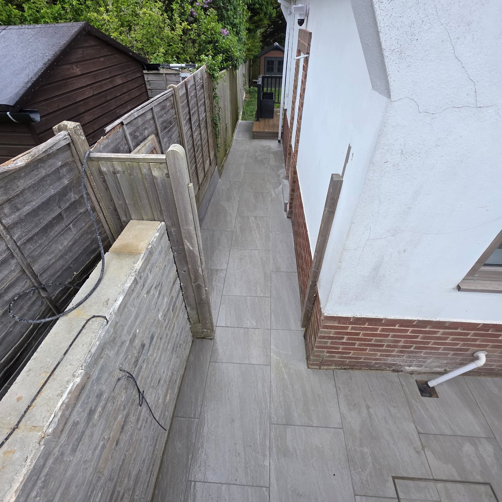 Tiled side passage beside a rendered house