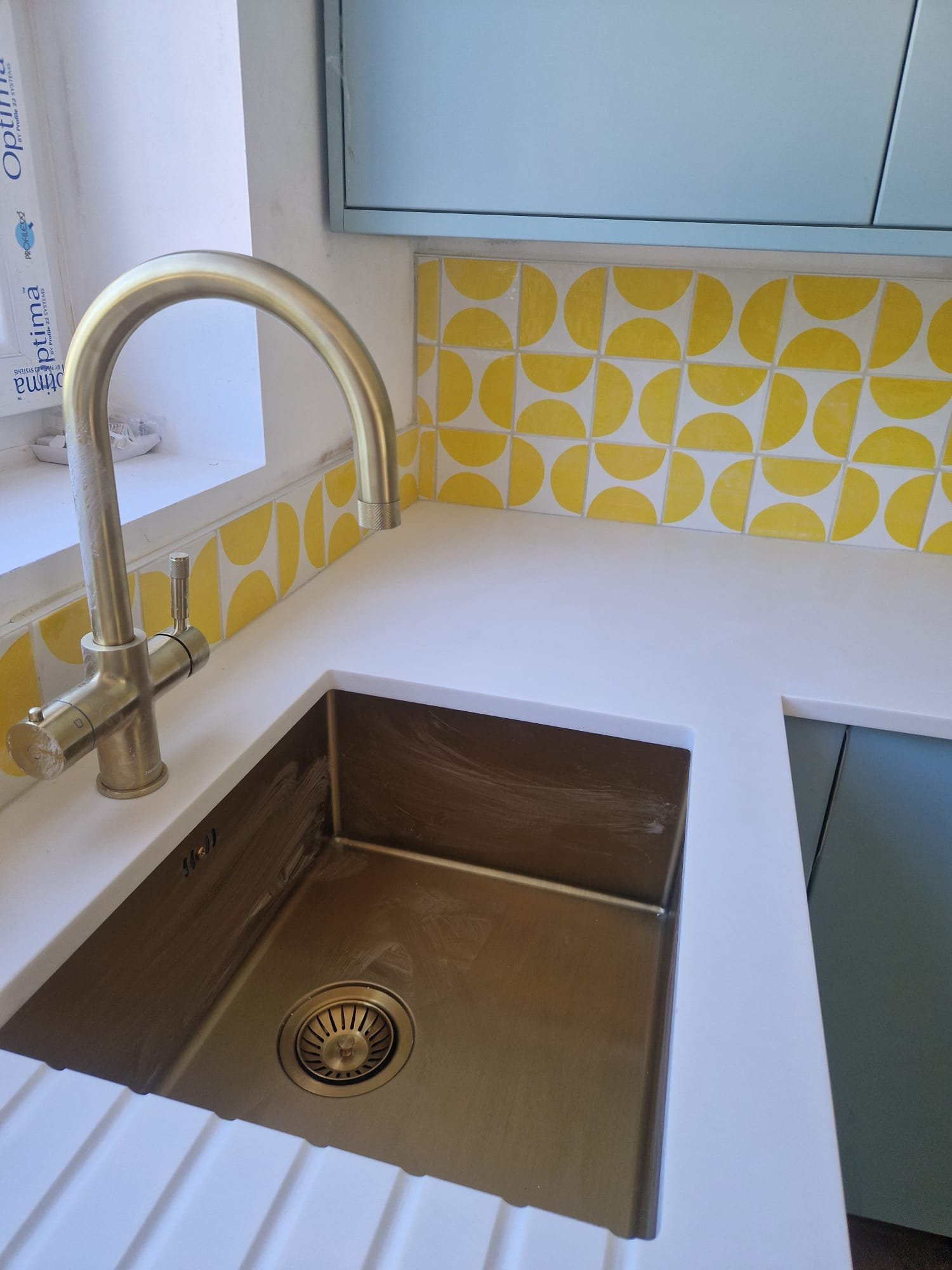 Patterned splashback tiling & brass kitchen tap